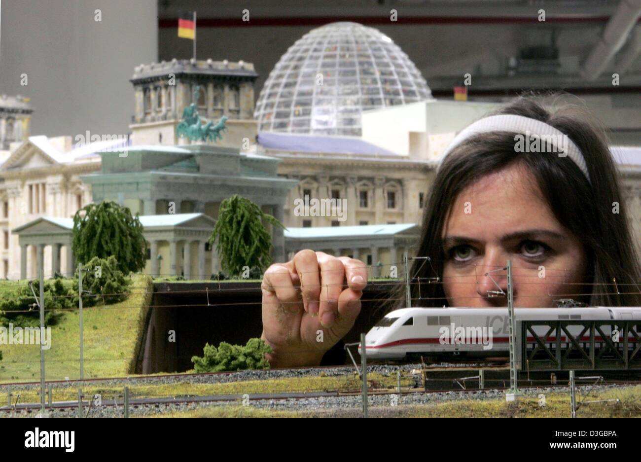 (Dpa) - Model Maker Sylvia Menelao controlla la linea aerea di contatto vicino il palazzo del Reichstag e la Porta di Brandeburgo sulla più grande della Germania azionato in modo digitale modello ferroviario in un centro commerciale vicino stazione ferroviaria Zoo di Berlino in Germania, 15 settembre 2004. Fratelli Stefan e Henrik Goeddeke hanno investito quasi 3 milioni di euro nella versione del modello della capitale tedesca e sono therefo Foto Stock
