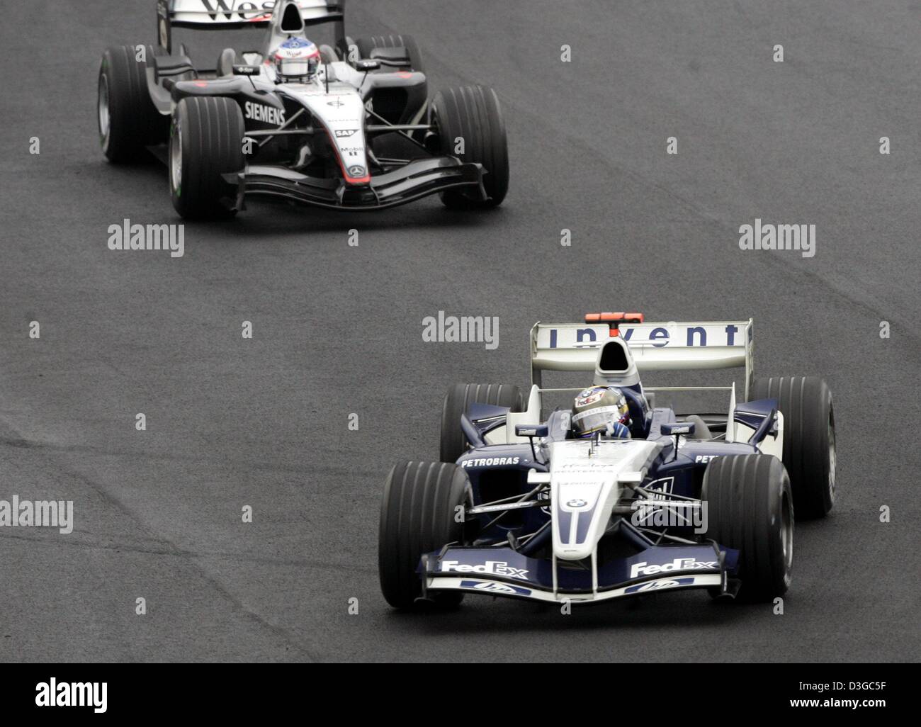 (Dpa) - colombiano di pilota di Formula Uno Juan Pablo Montoya (anteriore) della BMW-Williams è seguita dal finlandese Kimi Raeikkoenen della McLaren Mercedes durante il brasiliano FORMULA ONE Grand Prix sul circuito di Interlagos in Sao Paulo, Brasile, 24 ottobre 2004. Foto Stock