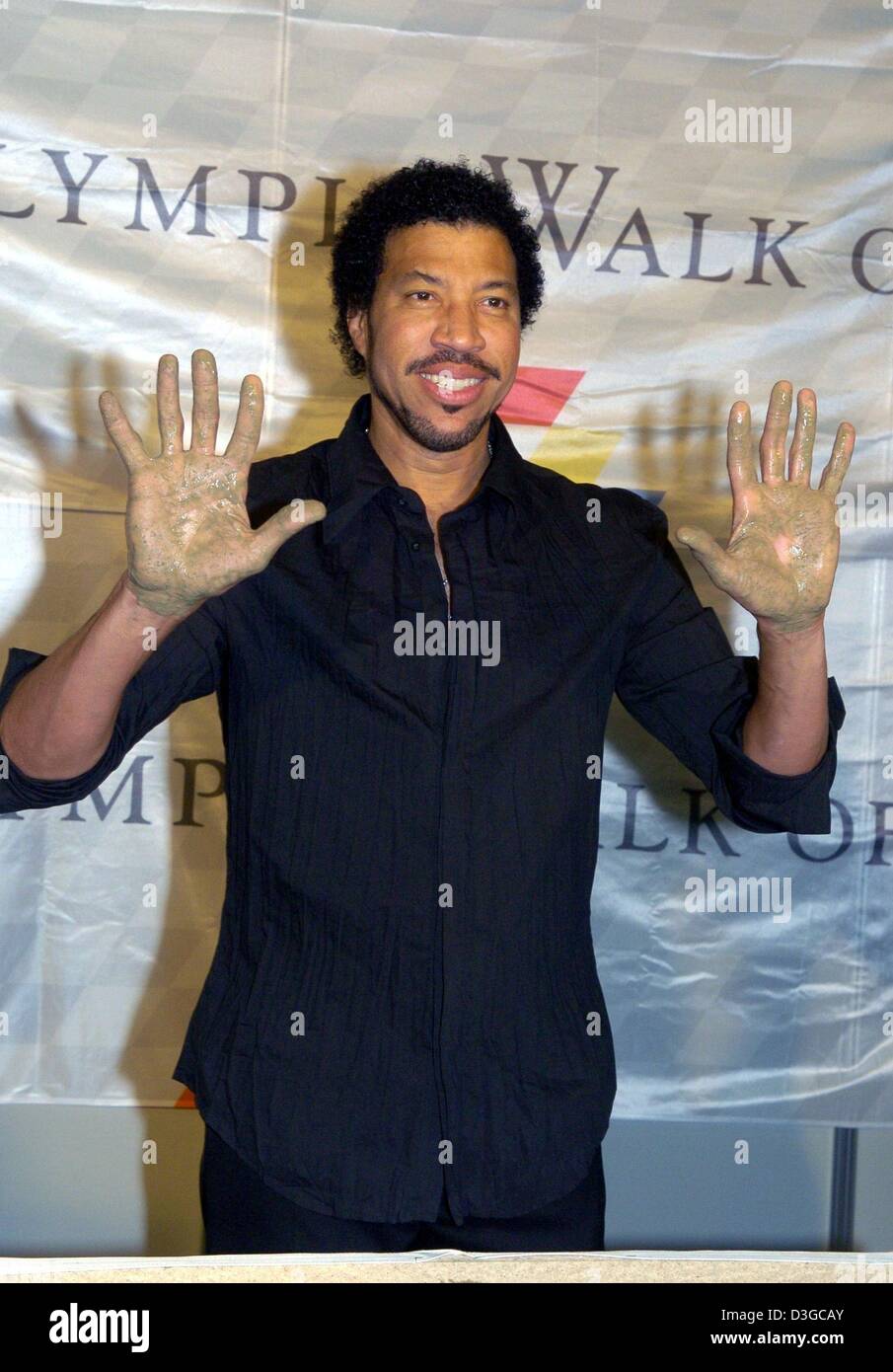 (Dpa) - US cantante Lionel Richie mostra i suoi palmi dopo che egli ha immortalato se stesso con la sua mano impressioni in cemento umido sul 'Munich Olympic a piedi di stelle" a Monaco di Baviera, Germania, 16 ottobre 2004. Famoso intrattenimento e sport stars sono onorato con il premio per i loro successi. Richie ha venduto 100 milioni di record e sbarcati 22 top ten hits. Foto Stock