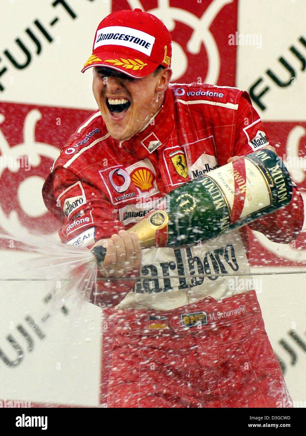 (Dpa) - Michael Schumacher (Ferrari), tedesco pilota di Formula Uno, cheers durante la cerimonia di consegna del premio dopo aver vinto il Gran Premio di Formula Uno racing circuito di Suzuka, in Giappone, 10 ottobre 2004. Michael Schumacher ha vinto la gara seguito da suo fratello che è arrivato secondo. Foto Stock