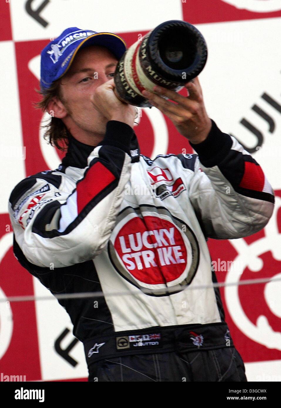 (Dpa) - Jenson Button (BAR-Honda), British formula one driver, bevande champagne durante la cerimonia di premiazione del Gran Premio di Formula Uno racing circuito di Suzuka, in Giappone, 10 ottobre 2004. Il pulsante è arrivato terzo. Foto Stock