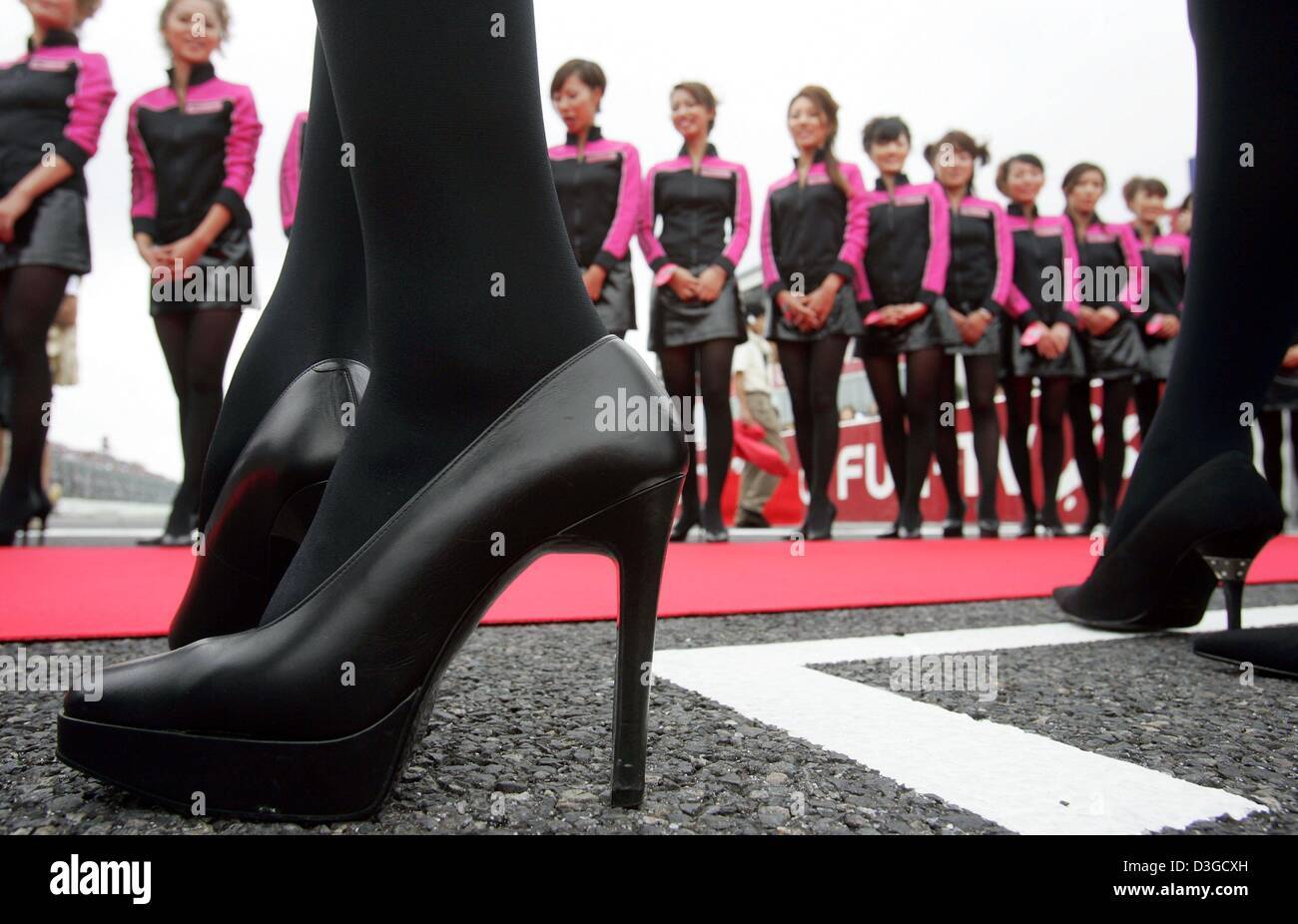 (Dpa) - Griglia giapponese ragazze formano una corsia durante il driver's Parade prima del Gran Premio sul circuito di gara a Suzuka, in Giappone, 10 ottobre 2004. Foto Stock