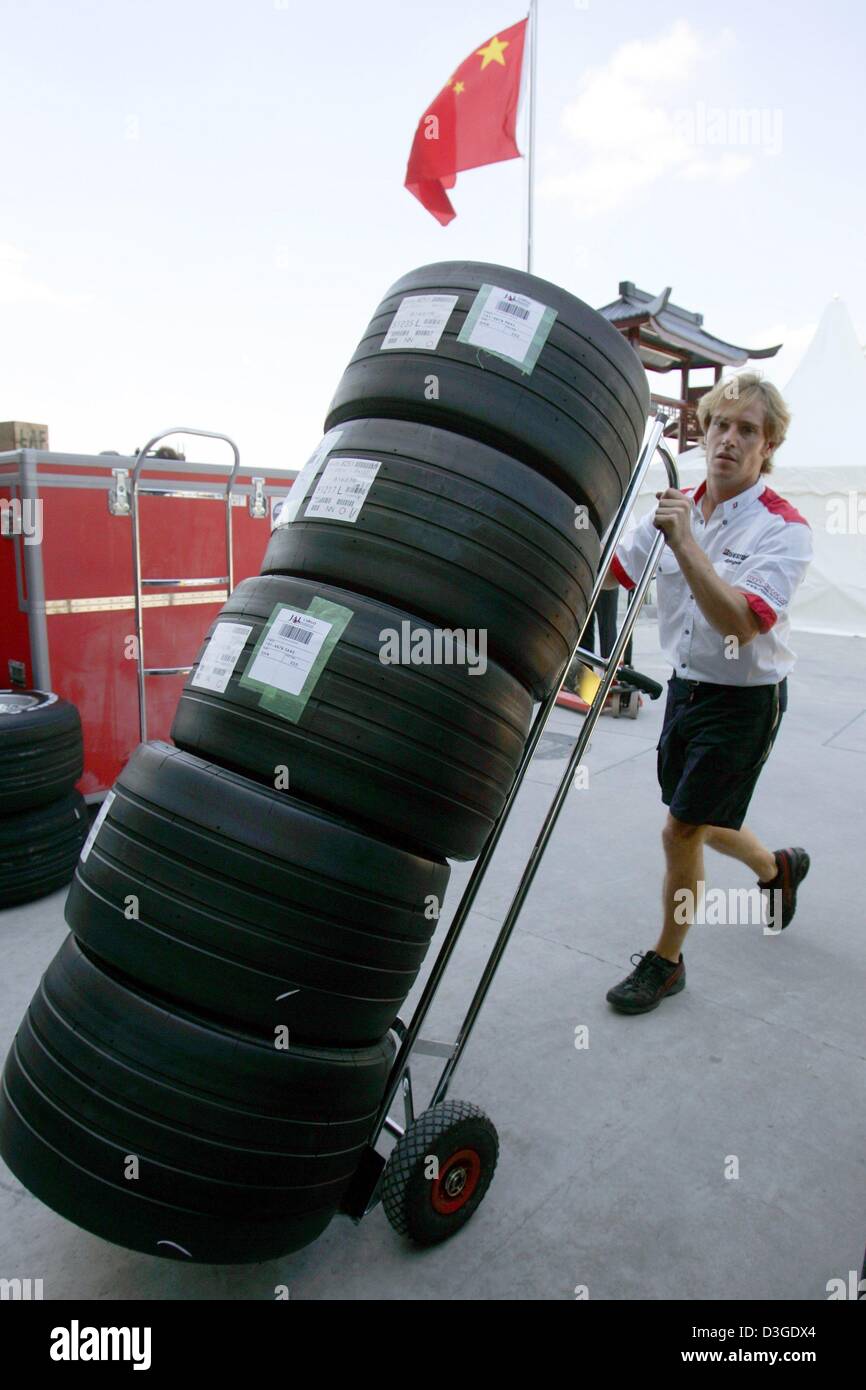 (Dpa) - Un tecnico spinge una fornitura di pneumatici Bridgestone attraverso il paddock di nuovo le corse di Formula Uno circuito di Shanghai, Cina, giovedì 23 settembre 2004. Il Gran Premio di Cina, in assoluto la prima gara di Formula Uno sul suolo cinese, avrà luogo la prossima domenica, 26 settembre 2004. Foto Stock