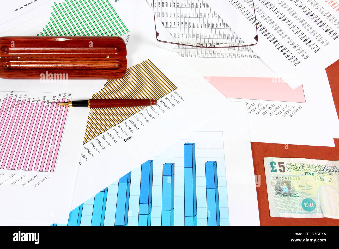 Gli oggetti business - prezzo carburante grafici, sterline britanniche, penna a inchiostro e bicchieri. Piano finanziario. Foto Stock