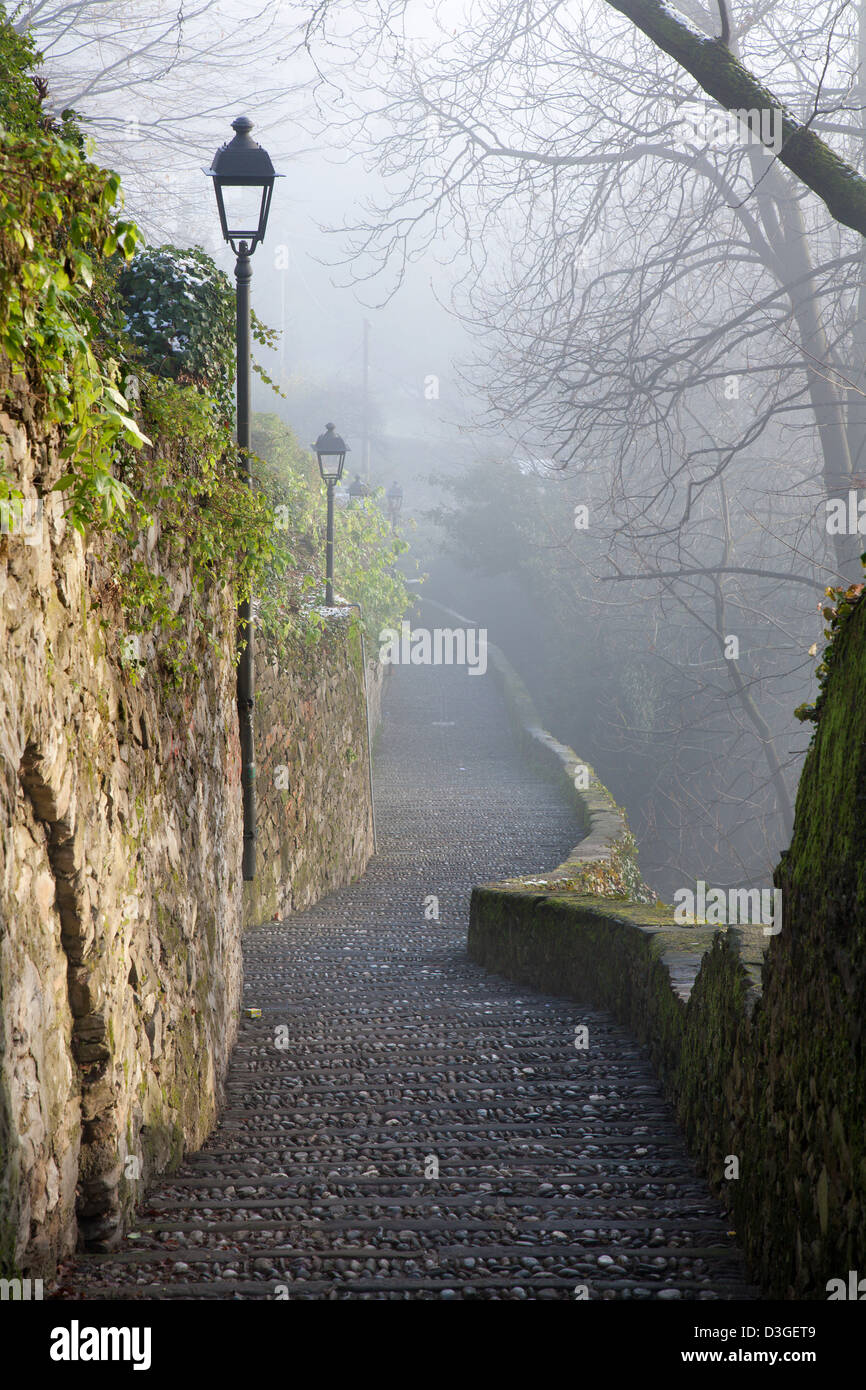 Bergamo - la salita di città alta in inverno la nebbia Foto Stock