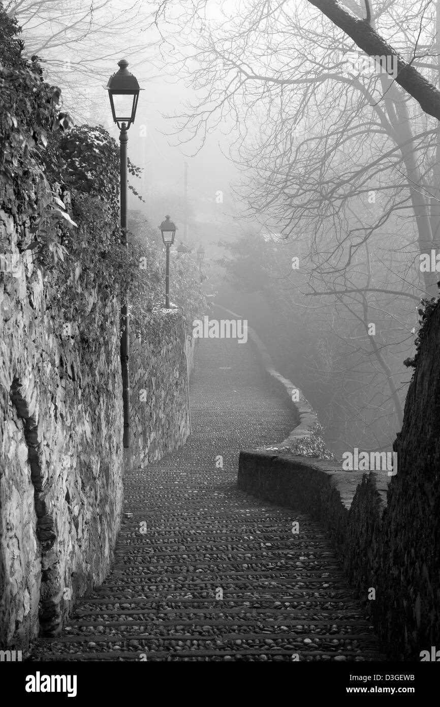 Bergamo - la salita di città alta in inverno la nebbia Foto Stock