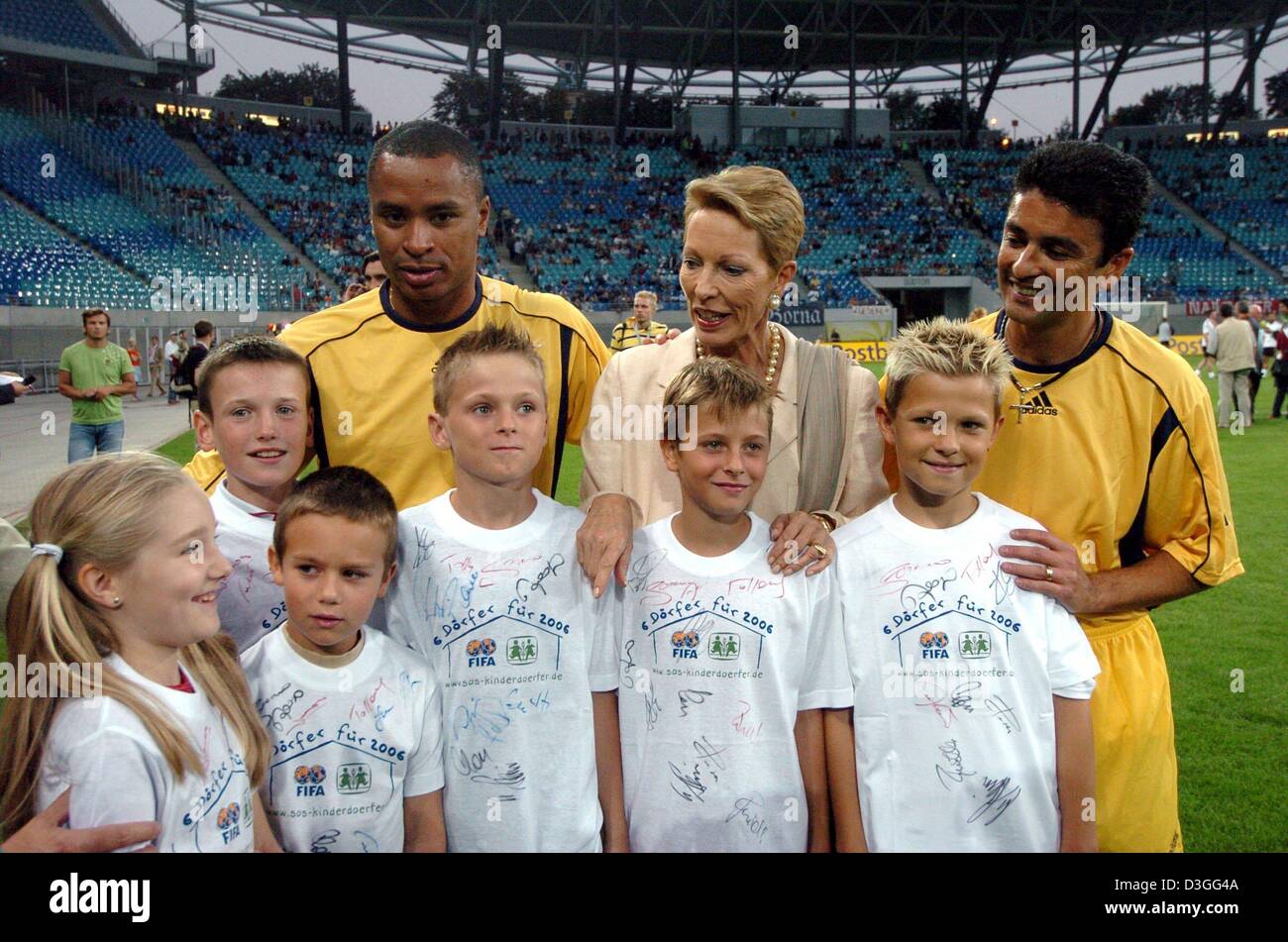 (Dpa) - Principessa Salima Aga Khan (C, indietro), Ambasciatore speciale del Villaggio SOS International (SOS Kinderdorf International) e ex-moglie di Aga Khan, in posa per una fotografia lungo brasiliano con i giocatori di calcio Paulo Sergio (L, indietro) e José Roberto Gama de Oliveira (R, indietro) e un gruppo di bambini prima di iniziare una carità partita di calcio al Zentralstadion in Lei Foto Stock