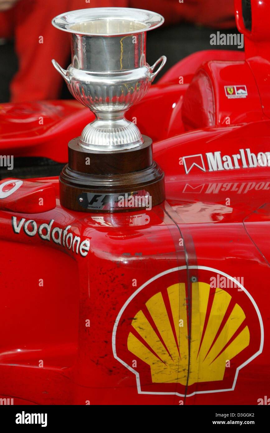 (Dpa) - Il Campionato trofeo si erge sulla Ferrari F2004 dopo il belga di FORMULA ONE Grand Prix in Spa, 29 agosto 2004. Il tedesco ferrarista Michael Schumacher ha terminato al secondo posto nel Grand Prix, graffatura di un inedito settimo titolo mondiale nonostante non vincere solo per la seconda volta in 14 gare in questa stagione. Foto Stock