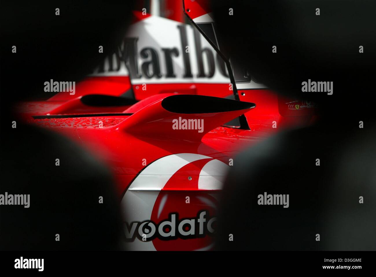 (Dpa) - Una vista attraverso una pila di gomme per la airscoops di una Ferrari F2004 race car su formula one racing pista di Spa Francorchamps, Belgio, 26 agosto 2004. Il Gran Premio del Belgio si terrà nella Spa di Domenica, 29 agosto 2004. Foto Stock