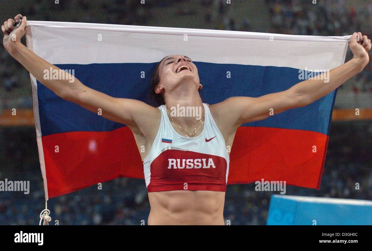 (Dpa) - Yelena Isinbayeva dalla Russia celebra mantenendo la sua nazione è bandiera dopo aver impostato un nuovo record del mondo a 4.91m che anche lei ha vinto la medaglia d'oro nel femminile Olympic caso Pole Vault allo Stadio Olimpico di Atene, Grecia, 24 agosto 2004. Foto Stock