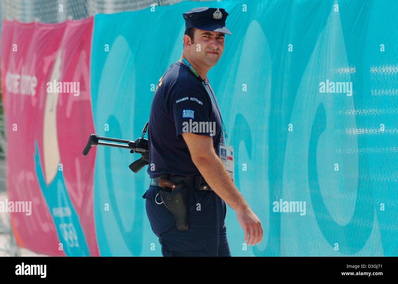 (Dpa) - un poliziotto armato custodisce un ingresso del OAKA Complesso Olimpico nelle ore del mattino a Atene, Grecia, 10 agosto 2004. Le autorità greche hanno speso circa un miliardo di euro sulla sicurezza per giochi d'estate. Il 2004 Olimpiadi di Atene inizierà venerdì 13 agosto 2004. Foto Stock