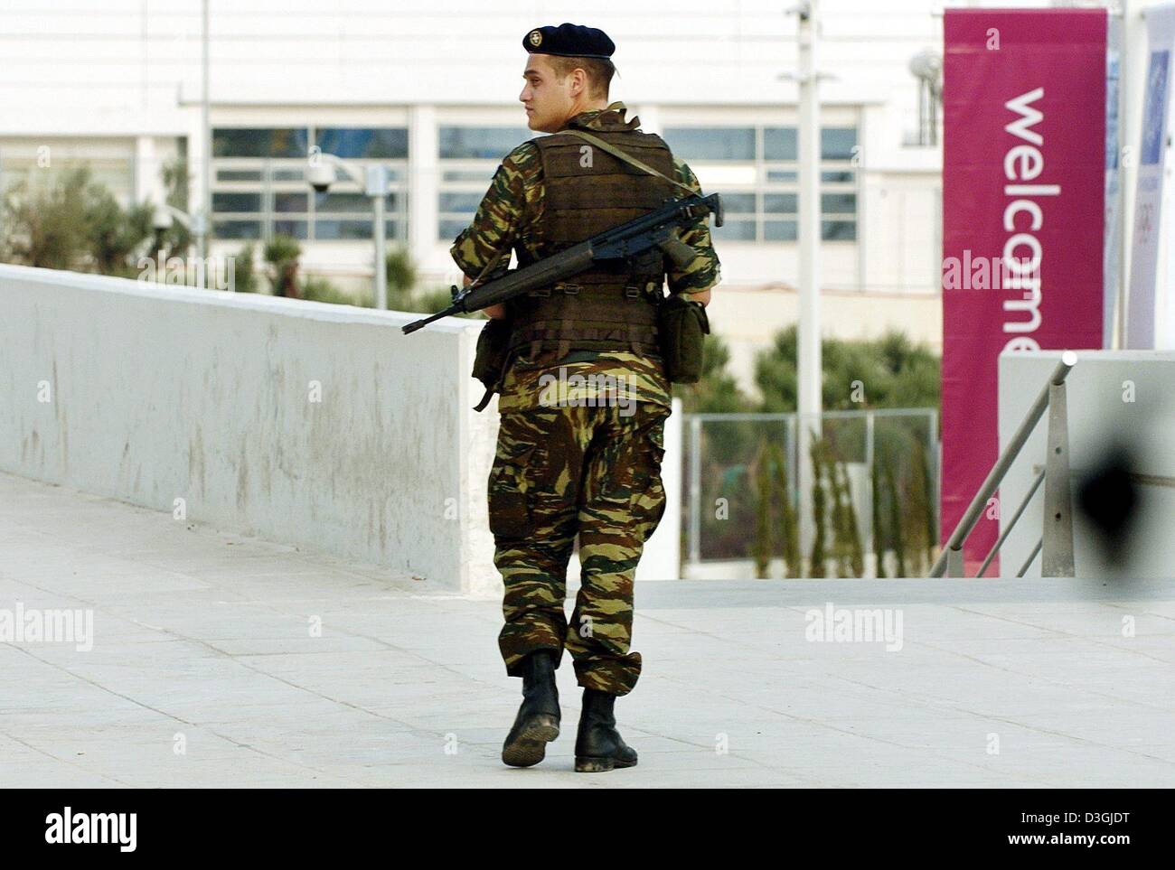 (Dpa) un membro dell'esercito greco con un mitragliatore pattuglie attraverso il parco olimpico di Atene il 07 agosto 2004. La XXVIII Giochi Olimpici si svolgerà nella capitale greca tra il 13 e il 29 agosto 2004. Foto Stock