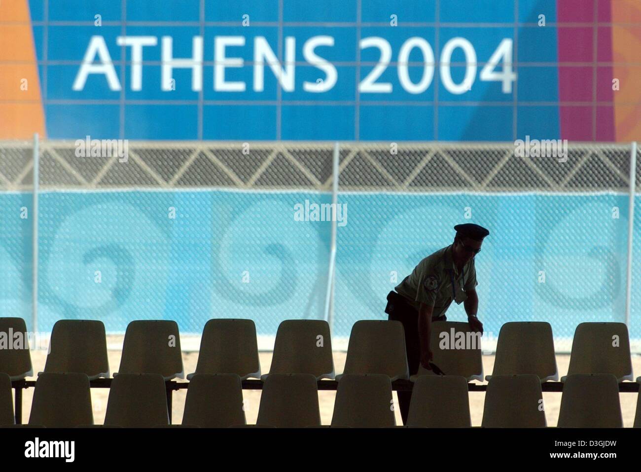 (Dpa) un membro delle forze di sicurezza controlla le sedi degli astanti in stadio Velodrom ad Atene il 07 agosto 2004. La XXVIII Giochi Olimpici si svolgerà nella capitale greca tra il 13 e il 29 agosto 2004. Foto Stock