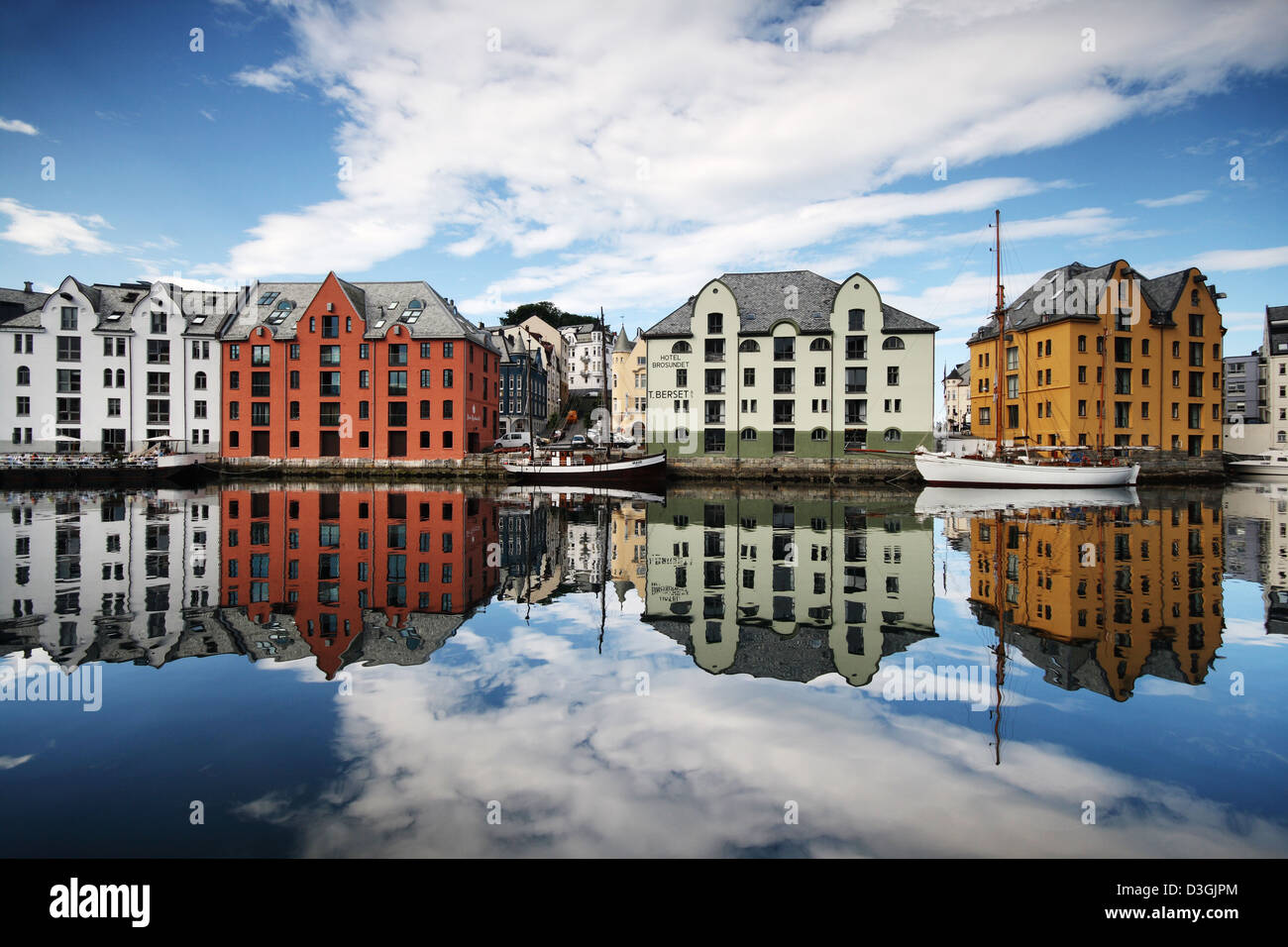 Ålesund - punto di riferimento sulla Norvegia la costa - tradizionale alte case norvegesi si riflette nel tranquillo canale. Foto Stock