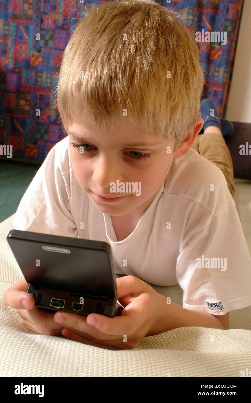 (Dpa) - un ragazzo giocando con il suo Nintendo Gameboy Advance, a Francoforte, in Germania, 7 luglio 2004. Foto Stock