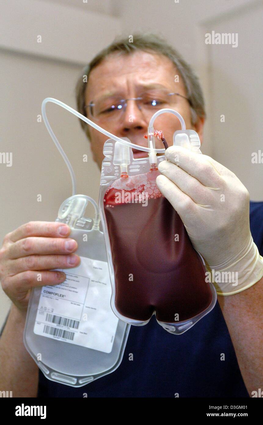 (Dpa) - Dirk Schrader, testa di una clinica veterinaria per piccoli animali domestici, detiene un contenitore di plastica riempito con sangue donato da un cane ad Amburgo, Germania, 18 maggio 2004. Schrader veterinario ha istituito una banca del sangue per cani a sua pratica. Per molti i canini il trattamento con plasma di sangue, sangue senza le cellule del sangue, è la loro ultima possibilità di sopravvivere. Foto Stock