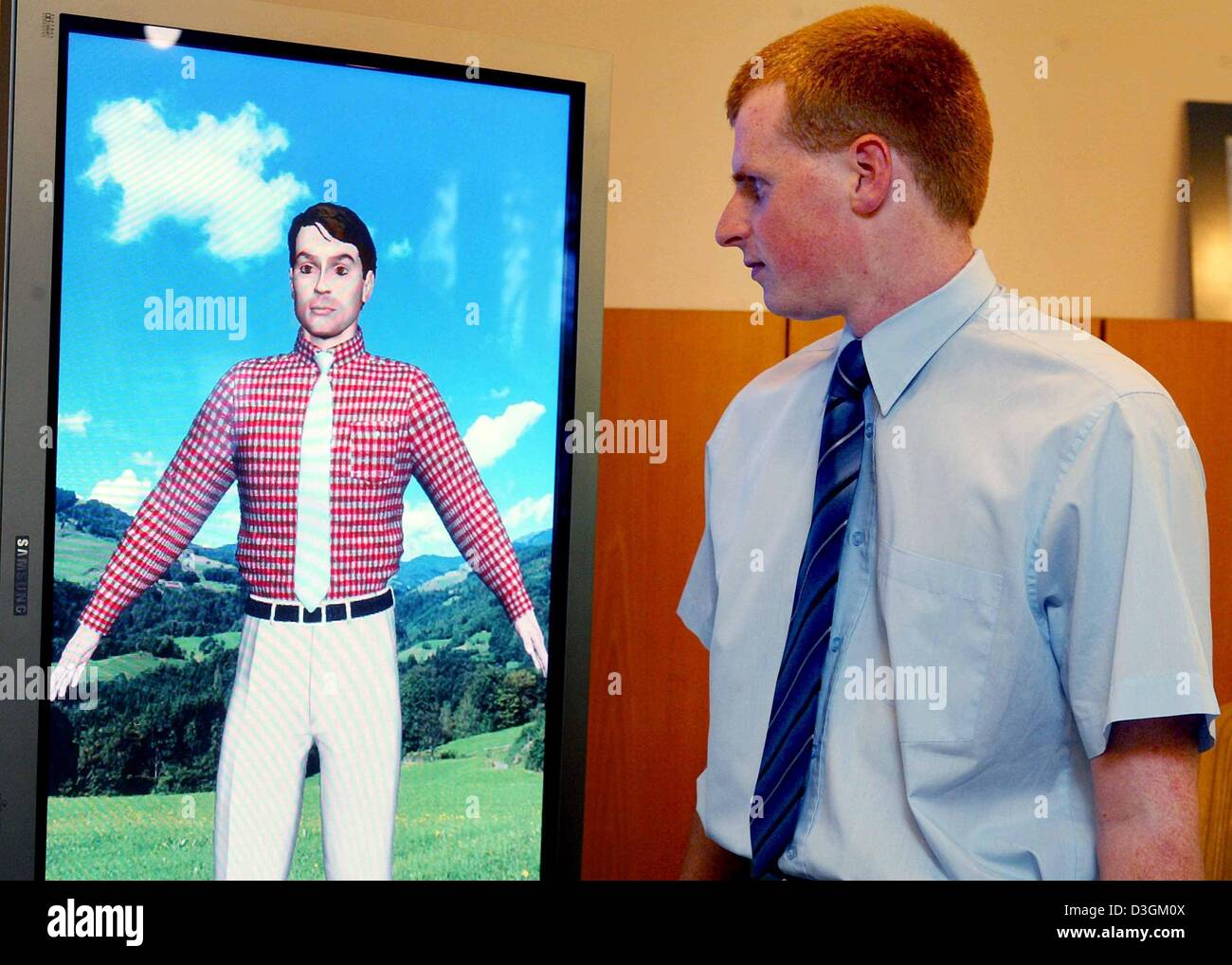 Dpa) - Un uomo esamina in un "specchio virtuale' computer immagine generata  da una maglietta con la sua dimensione in Francoforte sul Meno, Germania,  17 giugno 2004. "Specchio virtuale' consente ai clienti