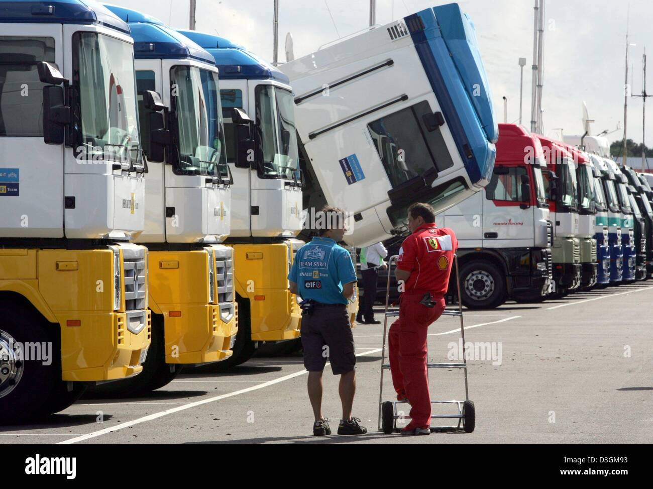 (Dpa) - una Renault e Ferrari dipendente chat nella parte anteriore di una fila del team parcheggiati i carrelli sulla gara di Silverstone corso a Silverstone, Gran Bretagna, giovedì 8 luglio 2004. Domenica 10 Luglio il Gran Premio di Gran Bretagna si svolgerà a Silverstone. Foto Stock