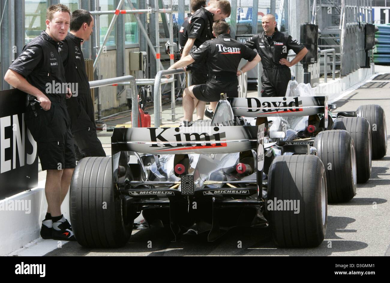 (Dpa) - McLaren-Mercedes meccanica sorge accanto alle vetture da corsa di Formula Uno driver Kimi Raeikkoenen e David Coulthard sulla gara di Magny Cours corso in Francia, 1 luglio 2004. Il Gran Premio di Francia sarà in corso domenica 4 luglio 2004. Il team utilizzerà un nuovo modello per la prima volta in occasione della gara. Foto Stock