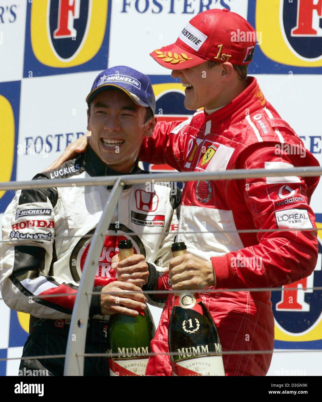 (Dpa) - tedesco di formula one champion Michael Schumacher (R) della Ferrari e il pilota giapponese Takuma Sato di BAR Honda celebrare con bottiglie di champagne dopo Schumacher ha vinto il Gran Premio degli Stati Uniti a Indianapolis, Stati Uniti d'America, 20 giugno 2004. Sato ha preso terzo posto Foto Stock