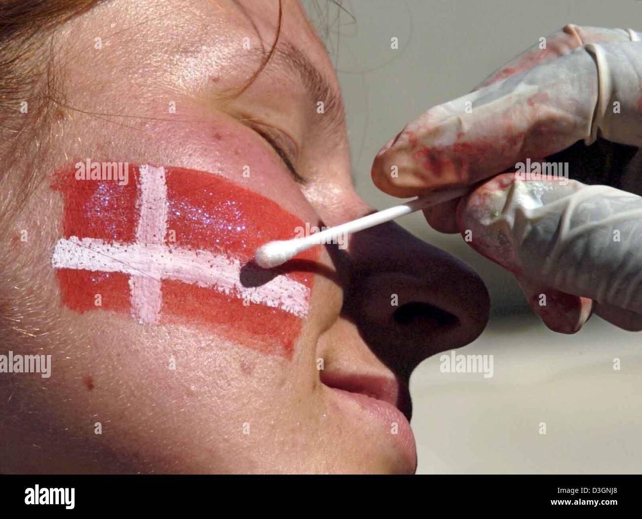 (Dpa) - una femmina di ventola danese ha il suo paese la bandiera dipinta sulla sua guancia prima di iniziare il primo round di Euro 2004 partita di calcio tra Italia e Danimarca al D. Afonso Henriques Stadium di Guimaraes, Portogallo, 14 giugno 2004. Il primo gioco di gruppo C si è conclusa in un 0-0. Foto Stock