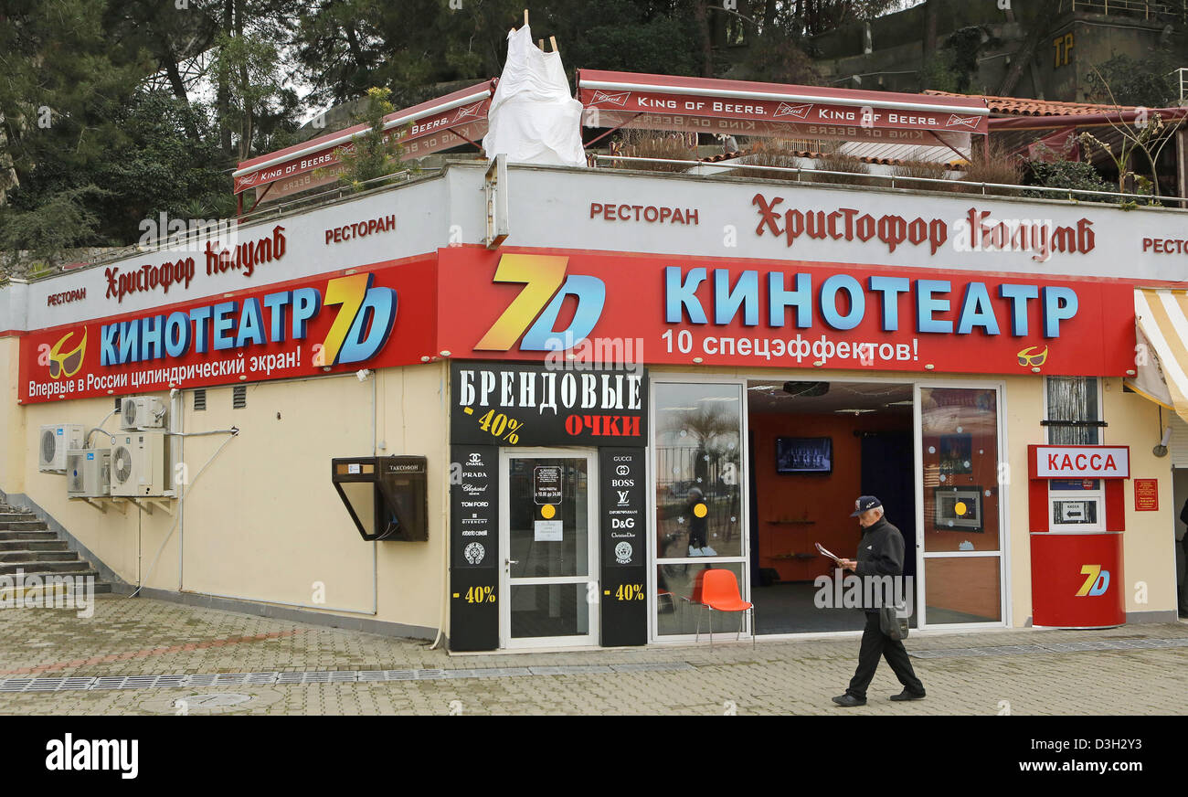 Un uomo cammina davanti ad una offerta di cinema 7D cinema sul lungomare a Sochi, Russia, 5 febbraio 2013. Il 2014 Olimpiadi invernali stanno andando a prendere posto nella località del Mar Nero di Sochi. Foto: Jan Woitas Foto Stock