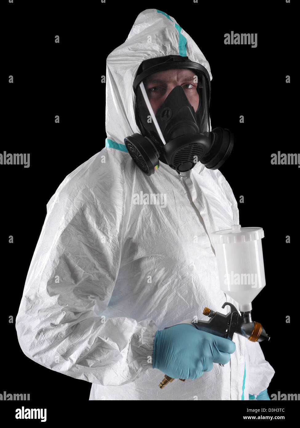 Pittore di spruzzo indossare tuta bianca, respiratore e la pistola a spruzzo colpo su sfondo nero Foto Stock