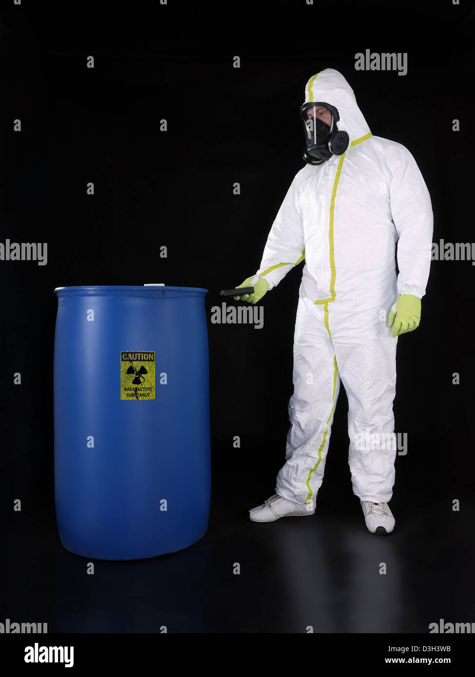 Uomo di indossare tuta protettiva controllo livello di radioattività della sostanza radioattiva memorizzati nel contenitore blu Foto Stock