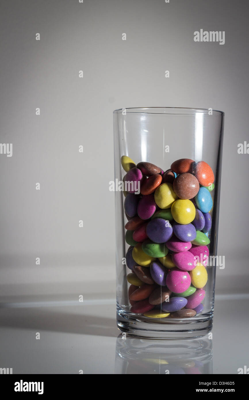 Colorato caramelle in vetro. evidenziando il contenuto di zucchero nelle bevande per i più giovani. Foto Stock