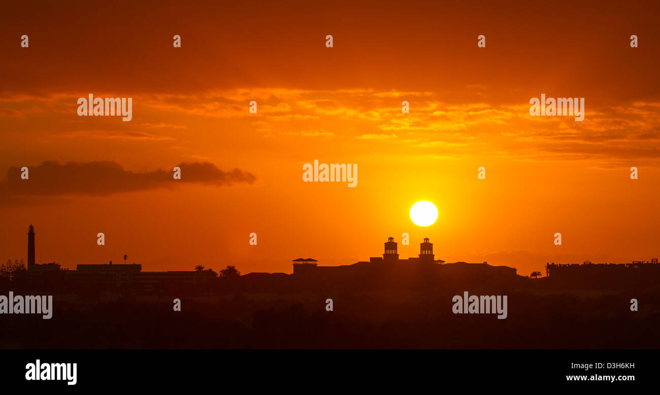 Faro di Maspalomas (sinistra) e il centro della città si stagliano nella tarda sera sun come si imposta su Gran Canaria Foto Stock