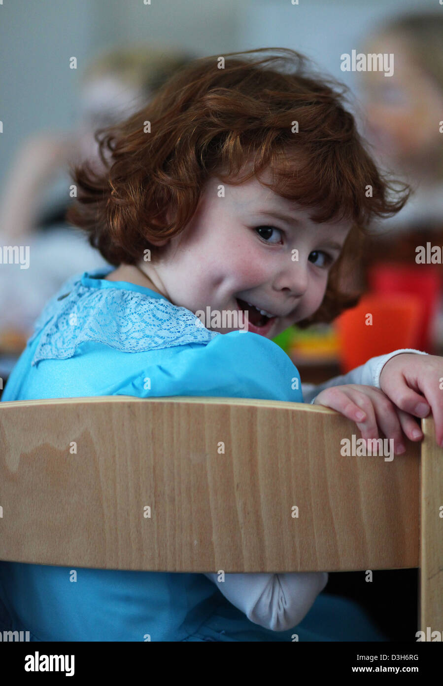 Ritratto di un tedesco di 4 anno vecchia ragazza seduta con altri bambini intorno a un tavolo nella scuola materna. Leipzig, Germania. Foto Stock