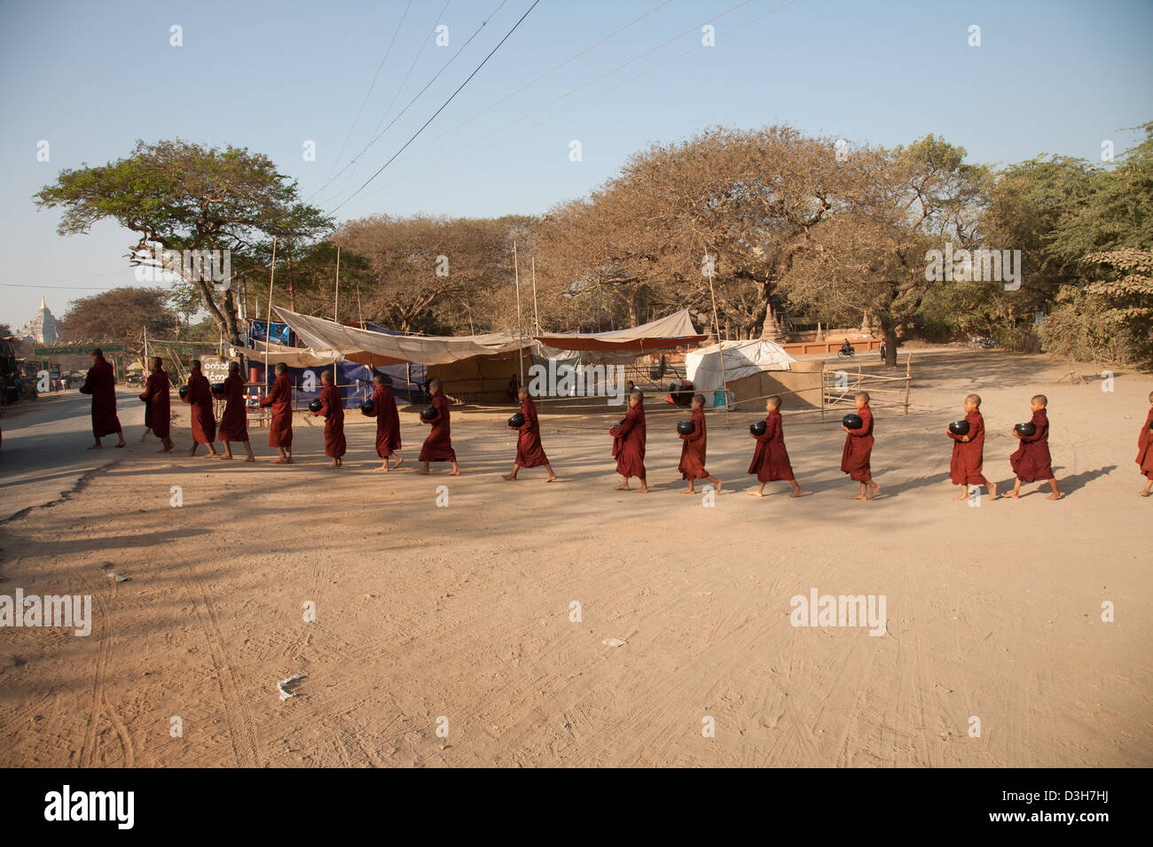 I monaci di Bagan raccogliendo elemosine al sorgere del sole Foto Stock