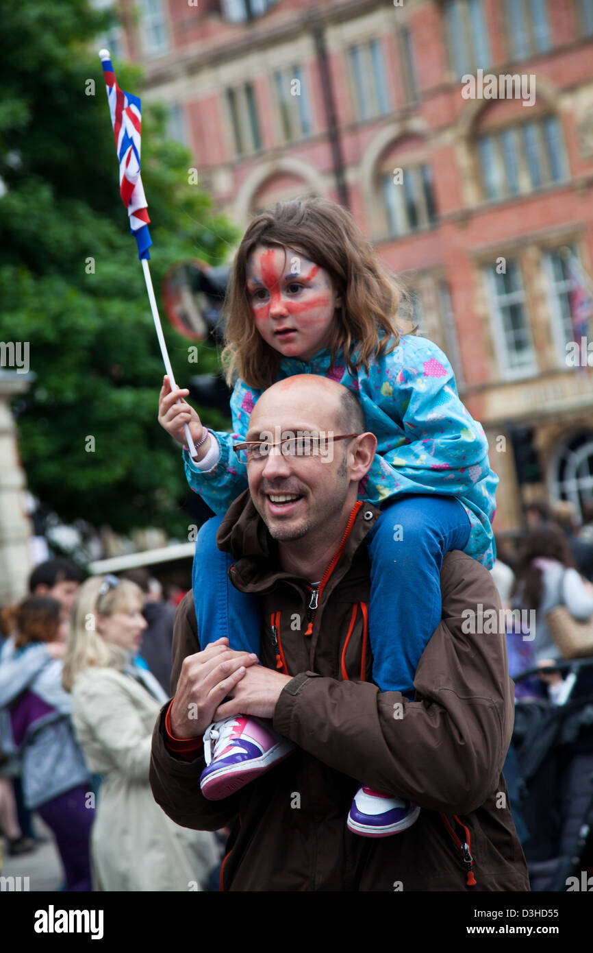 Padre tiene la sua figlia rinuncia a un flag durante la Regina Elisabetta II Diamond celebrazioni giubilari in Londra, Regno Unito Foto Stock