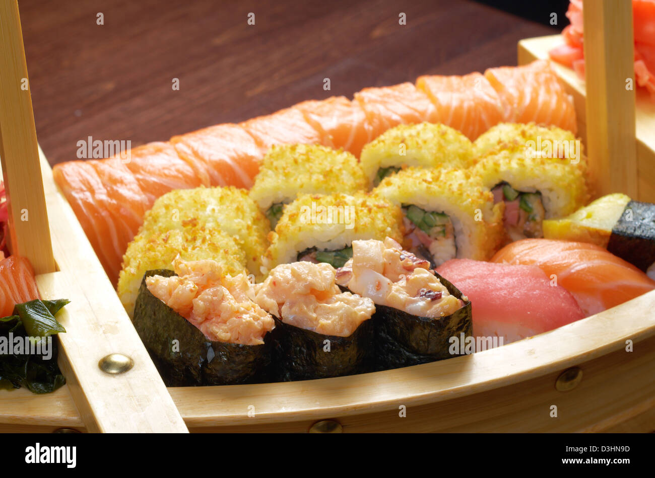 Un assortimento di sushi il cibo giapponese sulla nave tradizionale giapponese del cibo. Foto Stock