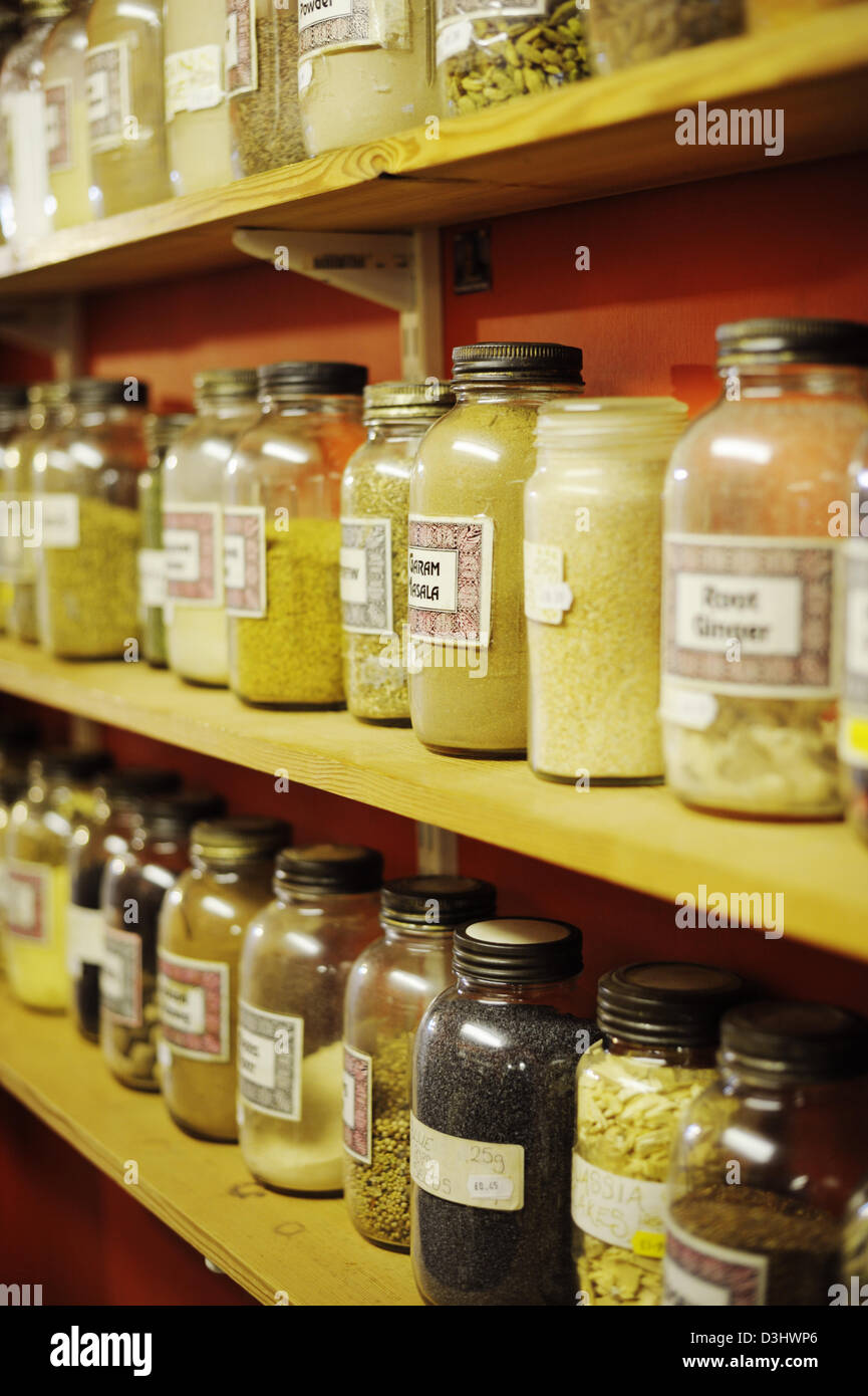 Vasetti di erbe aromatiche essiccate e le spezie su scaffali in un health food shop, il Galles. Foto Stock
