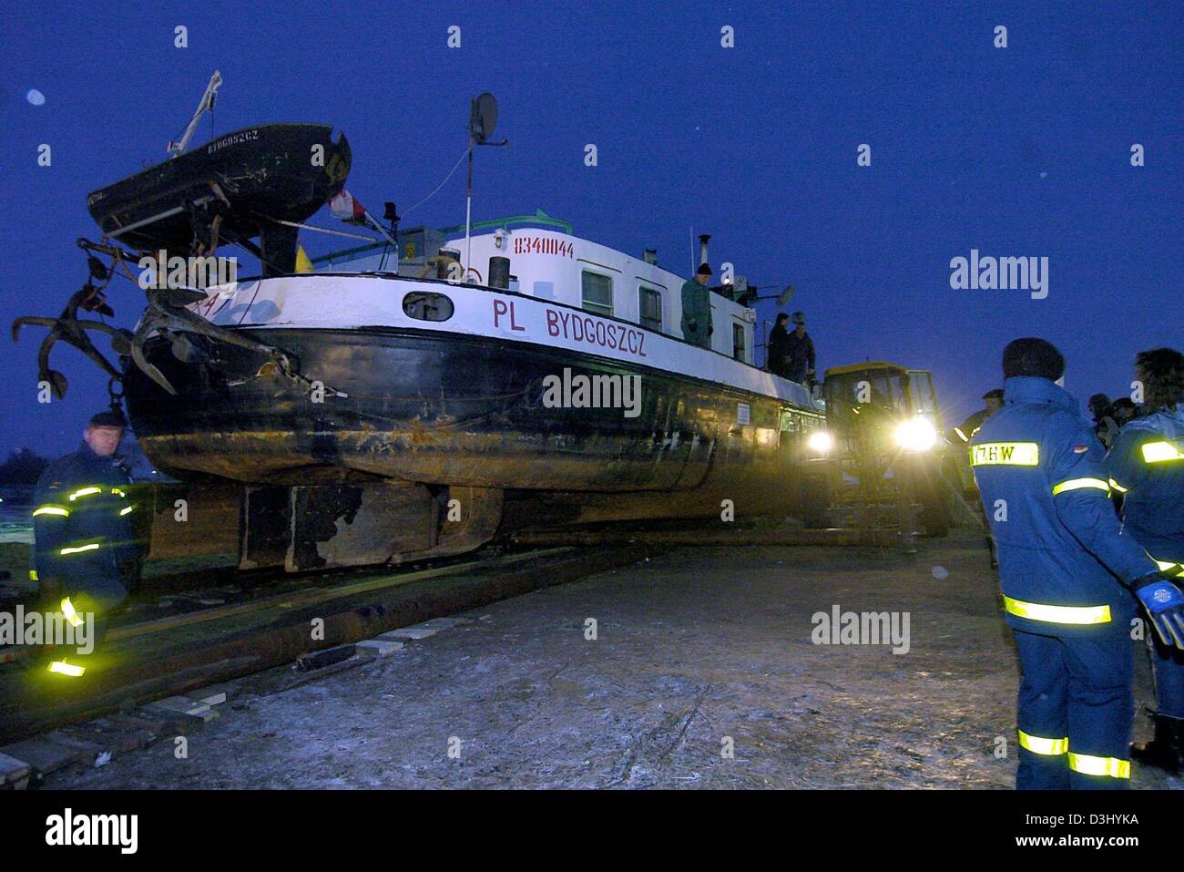 (Dpa) - La nave di un comandante polacco che si è arenata dopo le inondazioni dieci mesi fa è spinto indietro verso il fiume Elba vicino Schnackenburg, Germania, 27 gennaio 2004. I soccorritori hanno dovuto utilizzare serbatoi e altre macchine per spostare la nave del peso di 450 tonnellate. Foto Stock