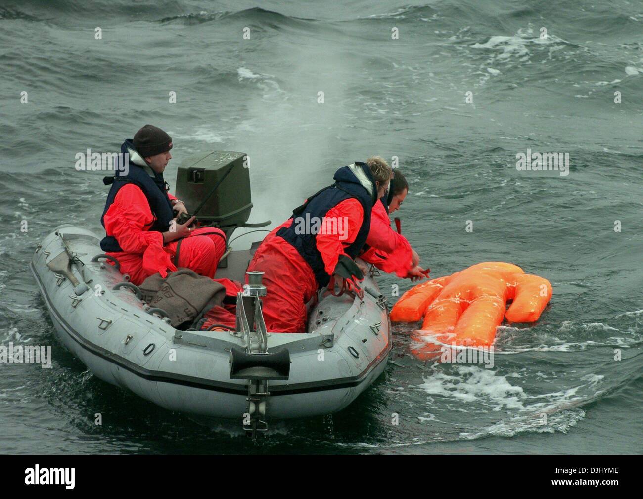 Tre marines a sedersi in un gommone e recuperare un manichino durante una manovra della Nato sul Mar Baltico nei pressi di Neustadt, Germania, 28 gennaio 2004. Sei imbarcazioni della marina da sei paesi hanno partecipato alla manovra che comprendevano anche esercizi di on-board per la lotta antincendio, il salvataggio dei feriti e assistere le navi in pericolo. Circa 400 truppe della marina hanno partecipato all'esercizio. Foto Stock