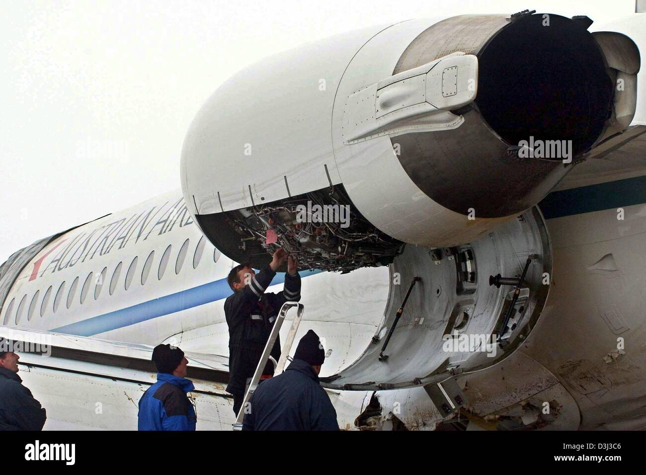 (Dpa) - Specialisti esaminare il motore sinistro della Austrian Airlines jet che ha effettuato un atterraggio di emergenza su 5 gennaio 2004 su un campo vicino all'aeroporto di Monaco di Baviera, Germania, il 8 gennaio 2004. Il piano può essere stata costretta a farlo a causa di un malfunzionamento del ghiaccio del sistema di protezione, investigatori detto 8 gennaio. Un primo esame ha rivelato che "l'impatto di ghiaccio vassoi' la schermatura e Foto Stock