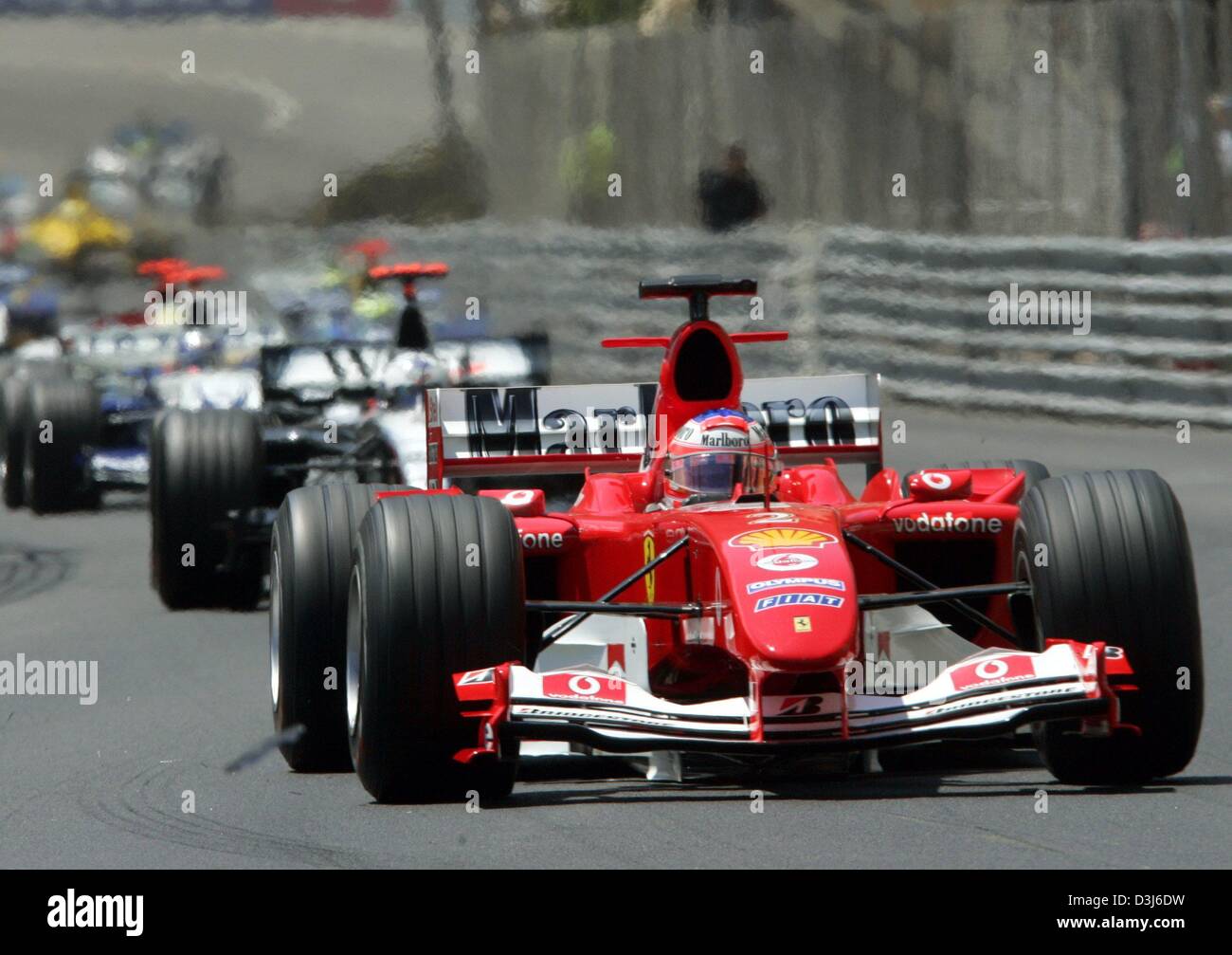 (Dpa) - Brasiliano pilota di Formula Uno Rubens Barrichello (anteriore) velocità con la sua Ferrari racing car lungo il corso della città durante il Grand Prix di Formula 1 di Monaco, 23 maggio 2004. Barrichello ha preso il secondo posto alle spalle di Jenson Button e di Jarno Trulli, che ha vinto il primo posto. Foto Stock