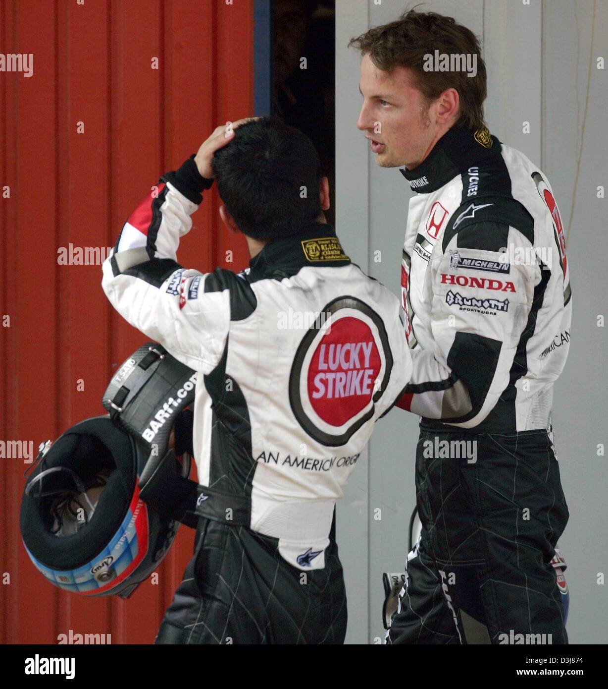 (Dpa) - I piloti della BAR-Honda formula one racing team, il giapponese Takuma Sato (L) e la Gran Bretagna è Jenson Button a piedi indietro alla loro casella dopo il Gran Premio di Spagna sul Circuito de Catalunya race track nei pressi di Barcellona, Spagna, 9 maggio 2004. Foto Stock