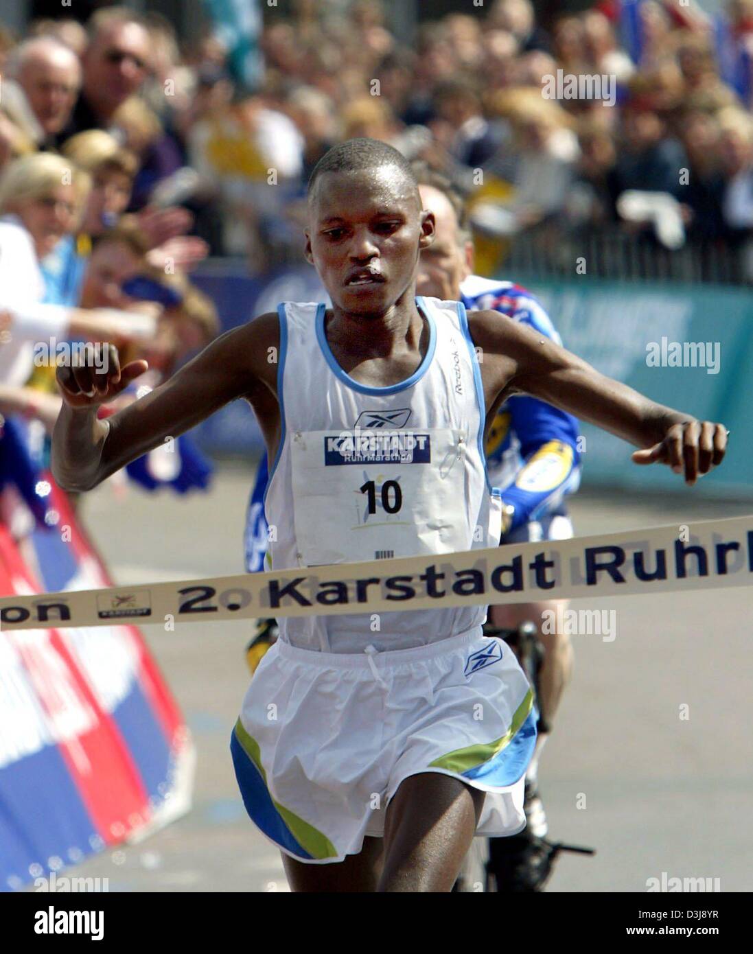 (Dpa) - Faustin Baha dalla Tanzania attraversa la linea del traguardo per conquistare il 2° Karstadt RuhrMarathon a Dortmund, Germania, il 25 aprile 2004. Il RuhrMarathon nel bacino della Ruhr conduce attraverso la vicina città di Dortmund, Bochum Herne, Gelsenkirchen e termina a Essen. Foto Stock