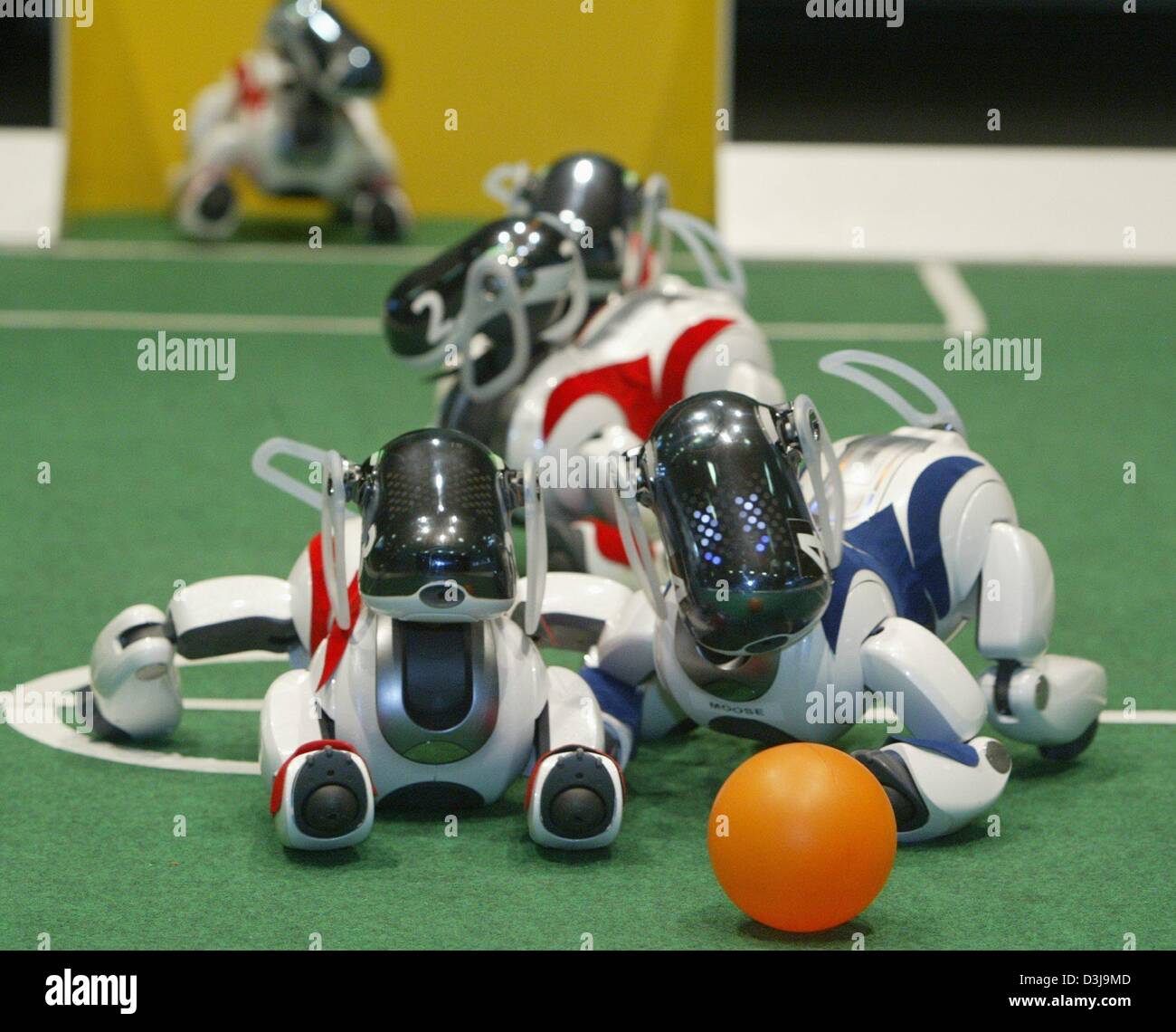 (Dpa) - Squadre di "Aibo' robot, da Sony, la lotta per la palla durante il "German Open' della Robocup 2004 soccer robot concorrenza in Paderborn, Germania, 2 aprile 2004. Quattro "Aibo' robot formano un team. Più di 150 squadre provenienti da 13 paesi prendono parte all'evento. Foto Stock