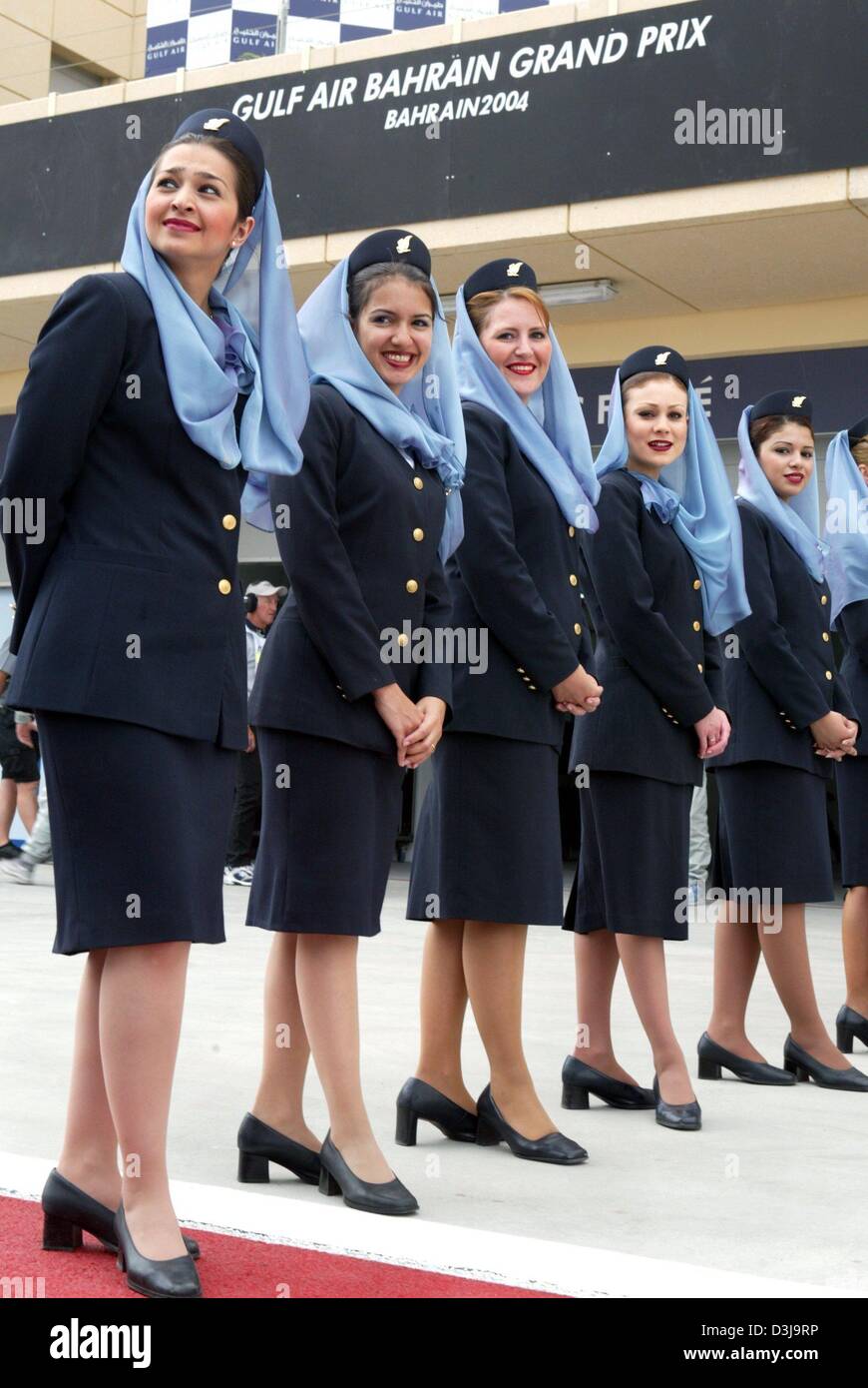 (Dpa) - Aria hostess della compagnia aerea Bahrainian servono come le ragazze della griglia sulla gara di Formula Uno via a Manama, Bahrein, 4 aprile 2004. A causa di motivi religiosi la griglia-ragazze in Bahrain devono indossare knee-gonne lunghe e un velo. Foto Stock