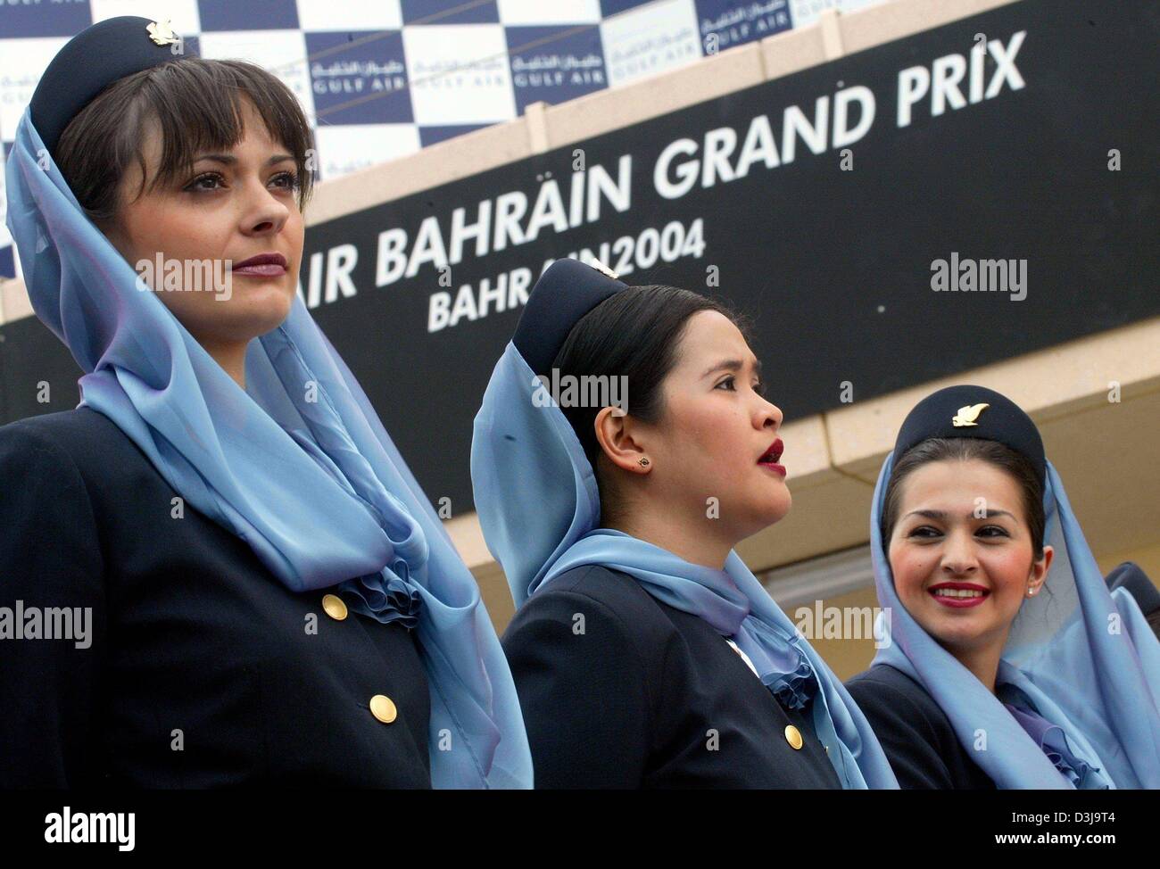 (Dpa) - Aria hostess della compagnia aerea Bahrainian servono come le ragazze della griglia sulla gara di Formula Uno via a Manama, Bahrein, 4 aprile 2004. A causa di motivi religiosi la griglia-ragazze in Bahrain devono indossare knee-gonne lunghe e un velo. Foto Stock