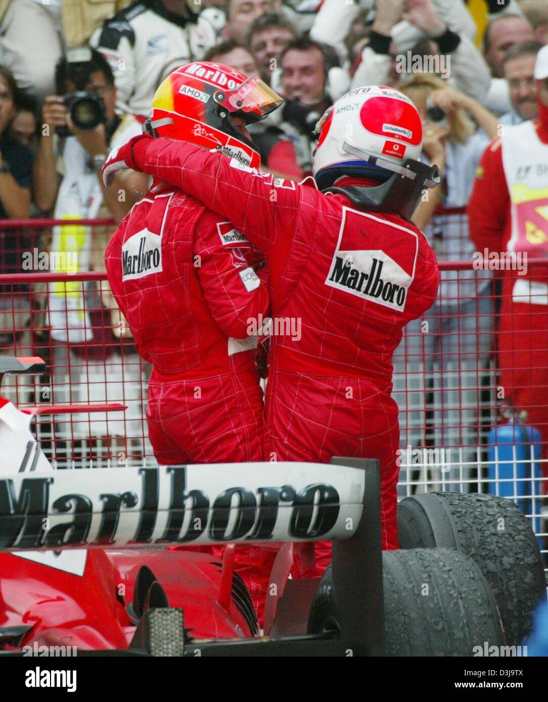 (Dpa) - Tedesco pilota di Formula Uno e vincitore Michael Schumacher e il suo compagno di squadra, il secondo posto di Rubens Barrichello (R), celebrare dopo aver terminato la corsa in Manama, Bahrein, 4 aprile 2004. Michael Schumacher ha vinto la prima mai Bahrain FORMULA ONE Grand Prix e il suo 73rd complessivamente, estendendo così il suo vantaggio nella classifica piloti con un perfetto tre vittorie su tre per la stagione Foto Stock