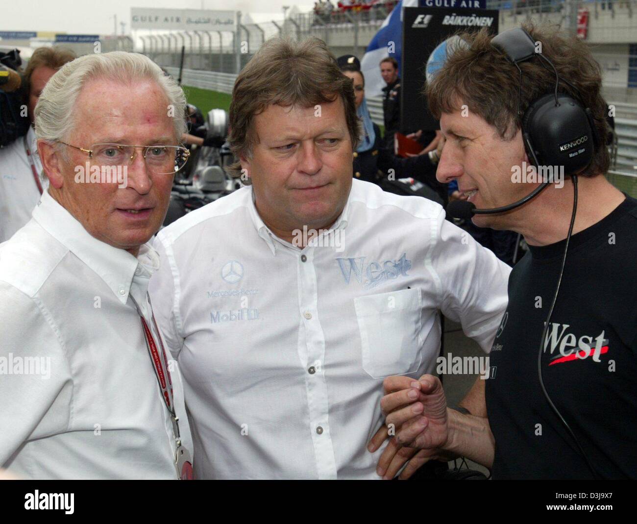 (Dpa) - Juergen Hubberth (L), Presidente della Casa di Stoccarda Norbert Haug, capo di Mercedes Motor Sports e Mario Illien, testa di ingegneria, parlare l uno con l altro in una gara di Formula Uno nel corso di Manama, Bahrein, 4 aprile 2004. Foto Stock