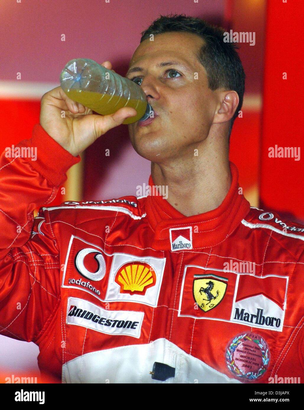 (Dpa) Il tedesco F1 campione del mondo Michael Schumacher bevande fuori della sua bottiglia come temepratures elevarsi fino a 40 gradi Celsius con un extrem umidità durante il corso di formazione gratuito presso la pista di Sepang vicino a Kuala Lumpur il Venerdì, 19 marzo 2004. Schumacher cadenzato il miglior tempo nella sua prima sessione di formazione e il quarto miglior nella seconda formazione gestita. Domenica, 21 marzo 2004, t Foto Stock