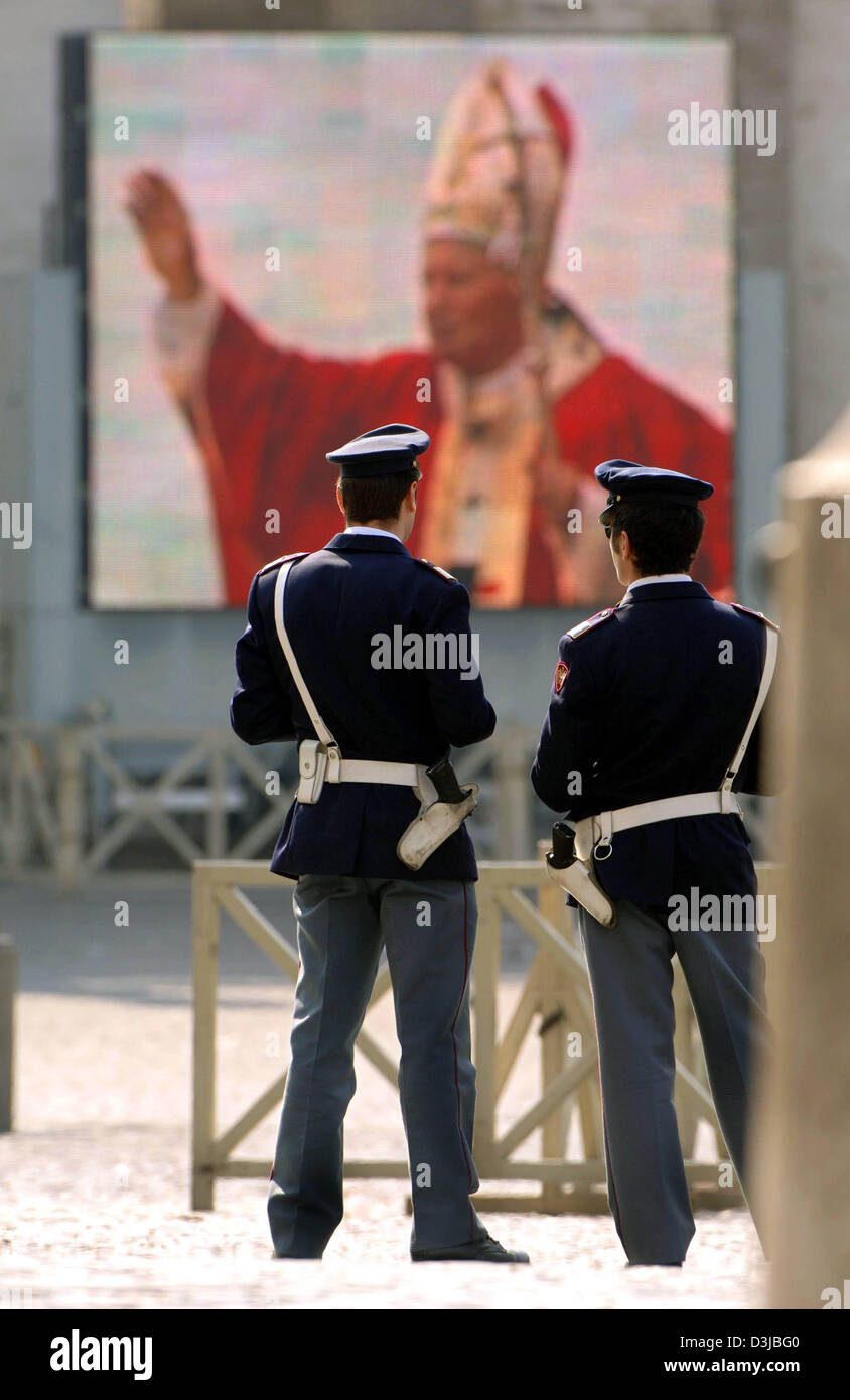 (Dpa) - gli ufficiali di polizia di stand di fronte a Piazza San Pietro dove diverse migliaia di credenti attendere in lunghe linee di fronte alla Basilica di San Pietro in Vaticano, lo Stato della Città del Vaticano, 5 aprile 2005. Diverse migliaia di persone provenienti da tutto il mondo parteciperanno qui le esequie di Papa Giovanni Paolo II il 8 aprile. Tra le persone in lutto sono più di 200 Stato e di capi di Stato e di governo di al Foto Stock