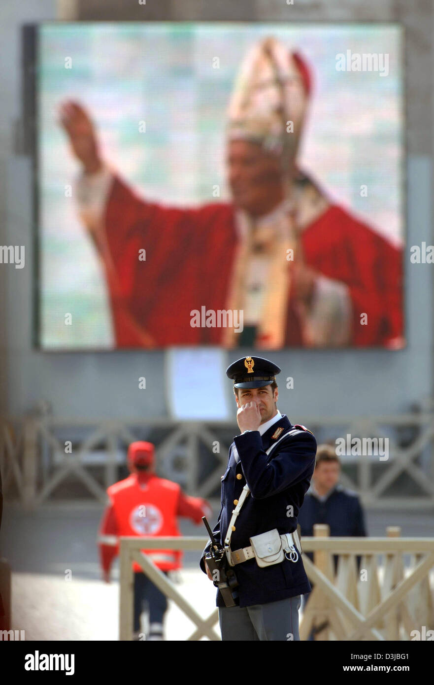 (Dpa) - Un funzionario di polizia si erge di fronte a Piazza San Pietro dove diverse migliaia di credenti attendere in lunghe linee di fronte alla Basilica di San Pietro in Vaticano, lo Stato della Città del Vaticano, 5 aprile 2005. Diverse migliaia di persone provenienti da tutto il mondo parteciperanno qui le esequie di Papa Giovanni Paolo II il 8 aprile. Tra le persone in lutto sono più di 200 Stato e di capi di Stato e di governo di Foto Stock