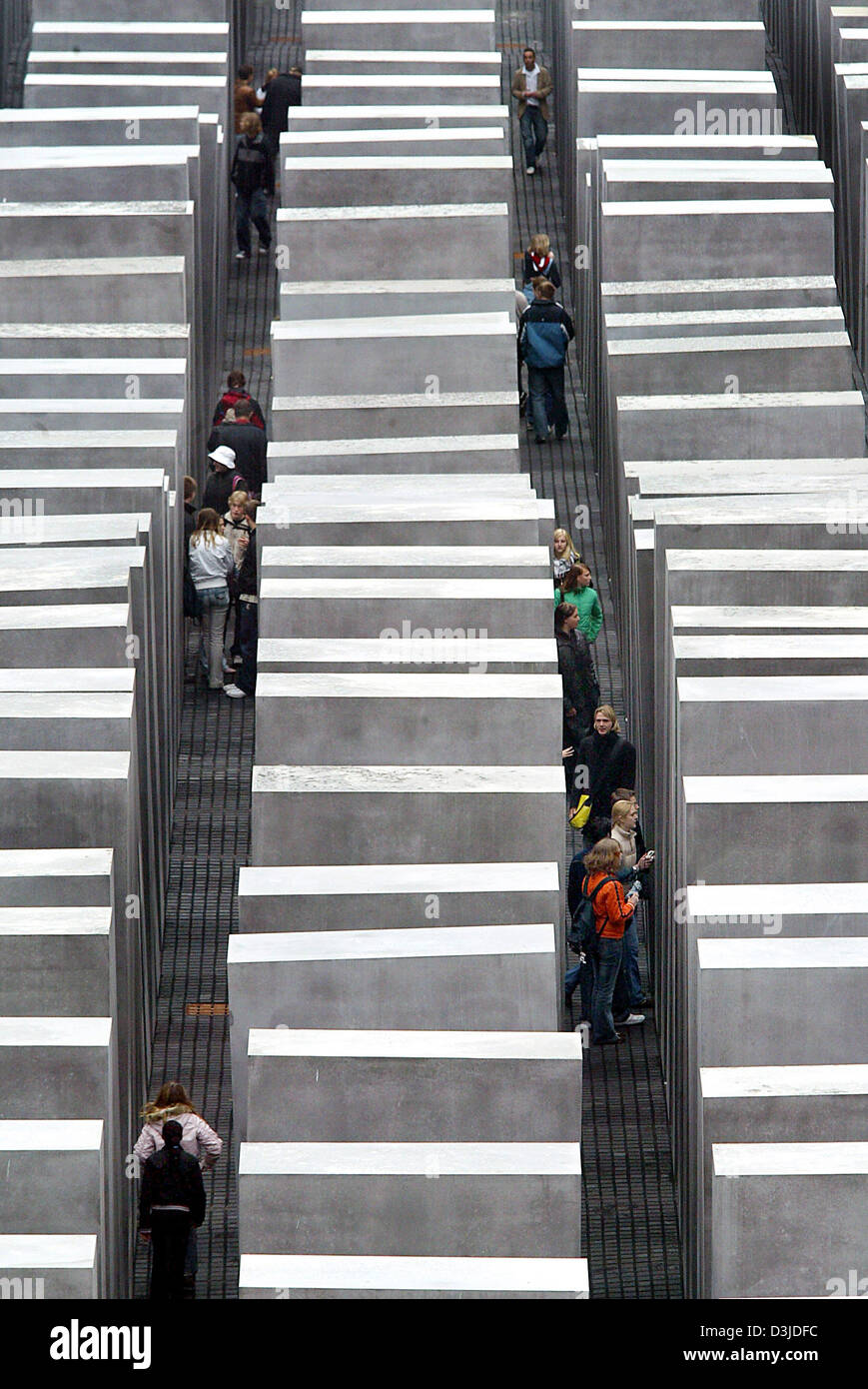 (Dpa) - visitatori a piedi tra le colonne di blocchi in calcestruzzo presso il Memoriale dell'Olocausto sito in Berlino, giovedì, 12 maggio 2005. Dopo anni di preparativi il memoriale per gli ebrei assassinati d'Europa, è stata ora aperta al pubblico. Foto Stock